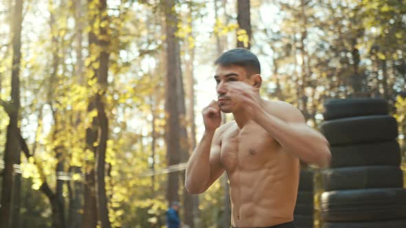 Man punching the air with his fists training warm-up before boxing workout outdoors