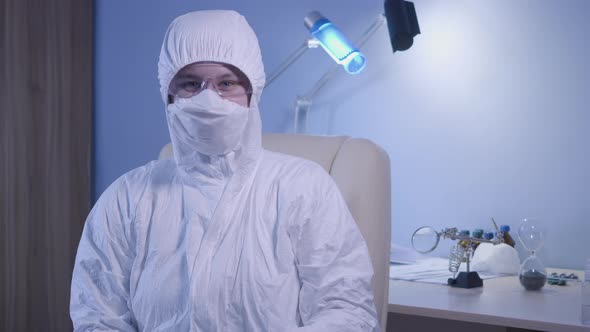 Young Happy Caucasian Doctor in Protective Suit Turning To Camera and Showing Thumb Up