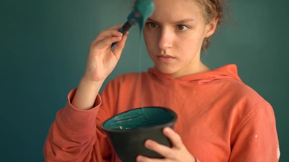 Teenager Watching Paint Fall Off From Paintbrush