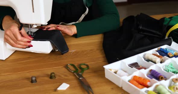 Step by step, 50-yers old woman sews clothes on sewing machine