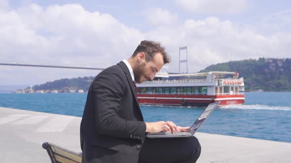Businessman working in his laptop in the Bosphorus.