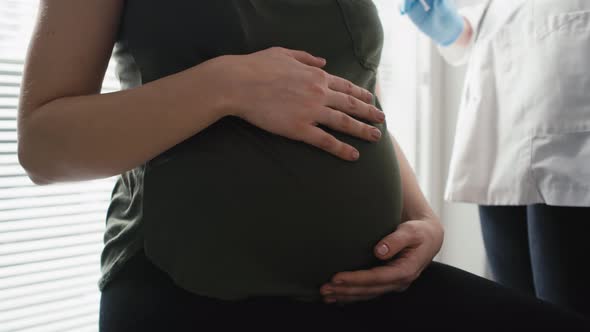 Detail of pregnant caucasian woman waiting for vaccination. Shot with RED helium camera in 8K.