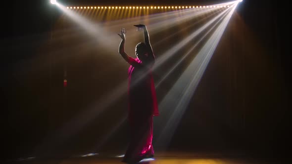 Silhouette a Young Girl Dancer in a Red Sari. Indian Folk Dance. Shot in a Dark Studio with Smoke