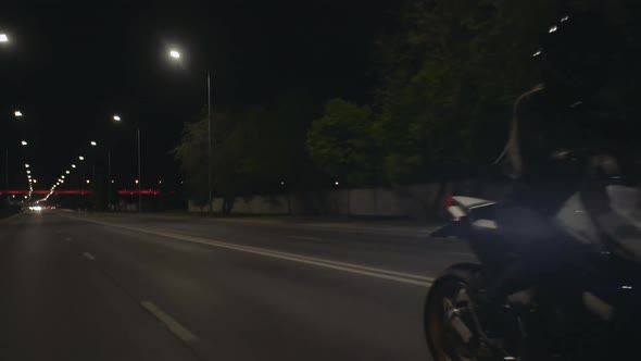 Young Woman in a Black Helmet Rides Motorbike and Shows Heart to the Camera