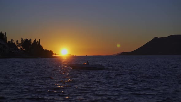 Wavy Ocean With Silhouetted Motorboat During Golden Hour. Static Shot