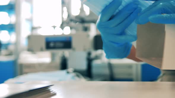 Factory Worker Packing Face Masks. Close Up