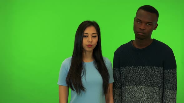 A Young Asian Woman and a Young Black Man Shake Their Heads at the Camera - Green Screen Studio