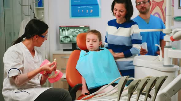 Stomatologist Explaining to Child the Surgery Using a Plaster Model of the Mandible