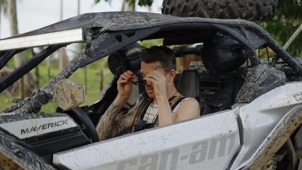 Caucasian Male Putting On Sunglasses Whilst Seated In Dirt Buggy Getting Ready To Drive Off In Punta