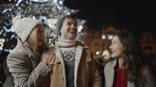 Three Friends Presenting Gifts to Each Other at Xmas Night at Old Town Square