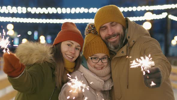 Happy Family With Sparklers Outdoors