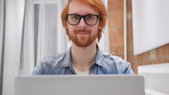 Portrait of Smiling Positive Redhead Beard Man Working on Laptop