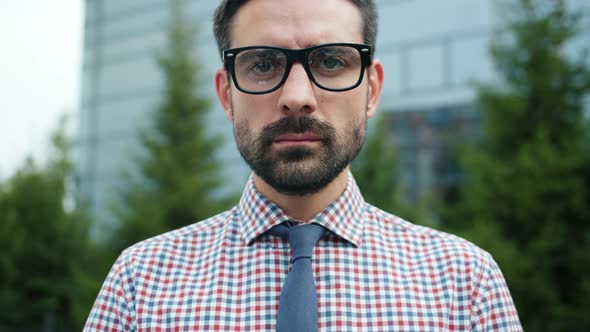 Portrait of Handsome Bearded Guy in Glasses Wearing Shirt and Tie Outdoors