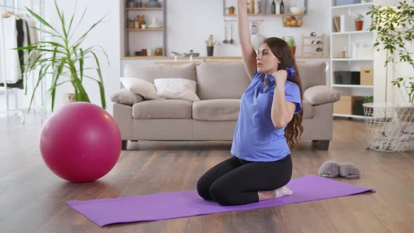 Happy Pregnant Woman Goes in for Sports at Home in the Living Room