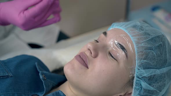 Cosmetologist Puts Sheets of Clear Foil on Girl Eyebrows