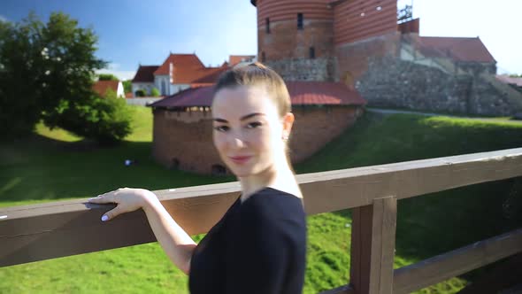 Close up on a dancer dancing in a park next to a castle