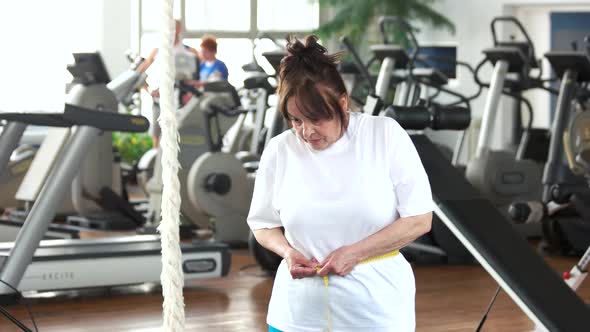 Senior Woman Measuring Her Waist at Gym