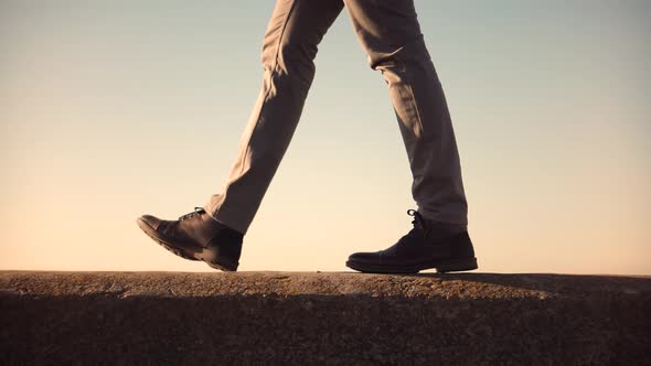 Man Legs In Shoes Walking On Parapet. Confidence Man Feet Walking In City. Good Weather At Fall.