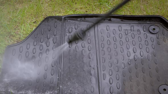 Close Up Cleaning of Car Mat with a Pressure Washer.