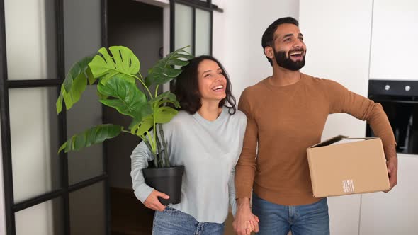 Attractive Couple Wearing Casual Clothing Moving Into New Home