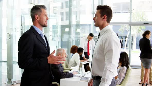 Businessmen shaking hands in office