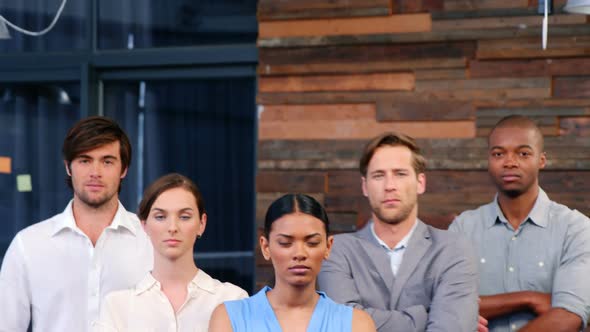 Portrait of business executives standing with arms crossed