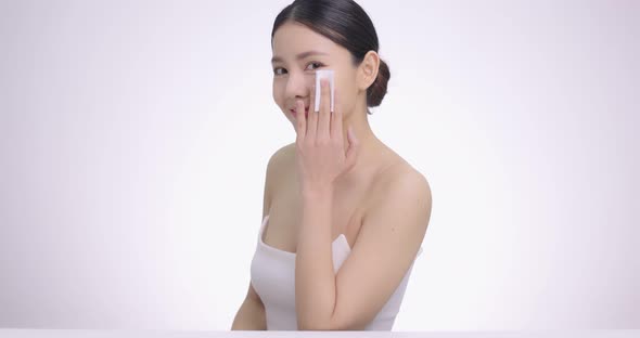 Beauty Portrait Of Young Attractive Asian Woman Cleaning Face With Cotton Pad Gently