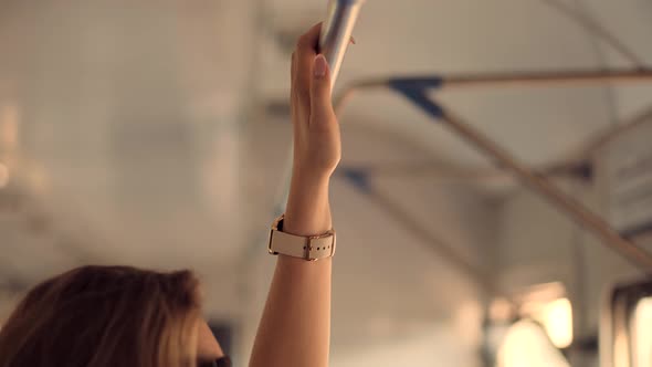 Woman Passenger Holding Handrail On Crowded Train Or Electric Train. Hand With Watch Taken Handrail