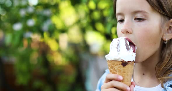 Cute Girl Eating Italian Ice Cream Cone Smiling While Resting in Park on Summer Day