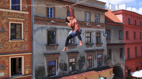 Man Balances on Tight Rope a View of the City From Height