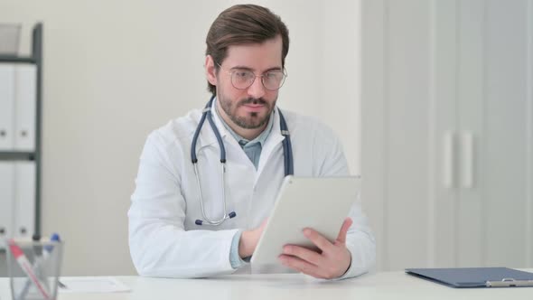 Young Male Doctor Using Tablet at Work