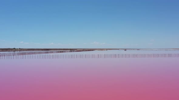 Flying over a pink salt lake. Salt production facilities saline evaporation pond fields 