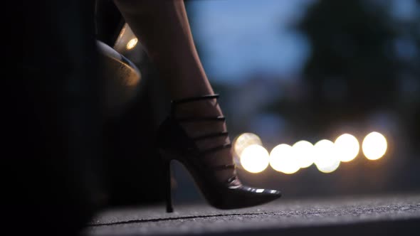Legs in High Heels Stepping Out of Car at Night