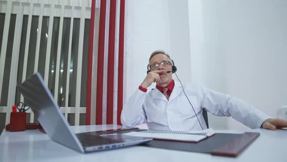 Physician with headset talks in medical office. 