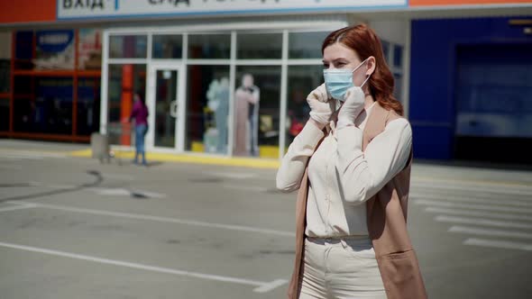 Young Female Shopper Puts on Medical Mask and Gloves To Protect Against Dangerous Deadly Virus in
