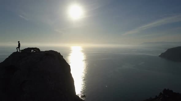 Young Woman in Mountains Waving Her Hand. Lady Reaching the Summit in Beautiful Scenery Over Sea