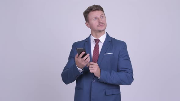 Handsome Bearded Businessman Thinking While Using Phone