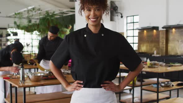 Mixed race female chef holding her waist