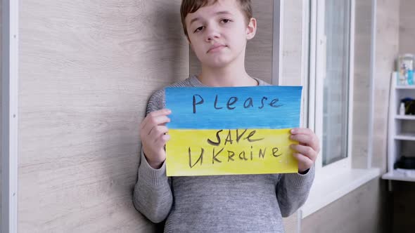 Child Holds a Banner with a Blue and Yellow Flag Message Please Save Ukraine