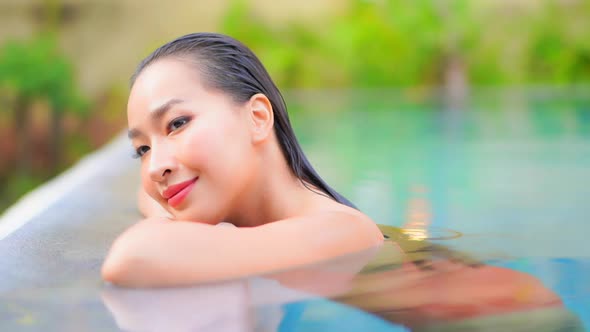 Young asian woman enjoy around outdoor swimming pool for leisure