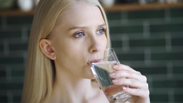 Woman Drinking Water From a Glass Indoors