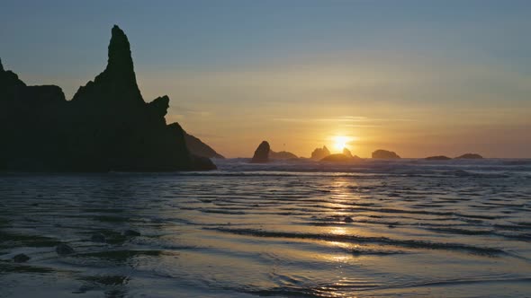 Sunset on Huge Sandy Ocean Beach Among Bizarre Stones and Rocks