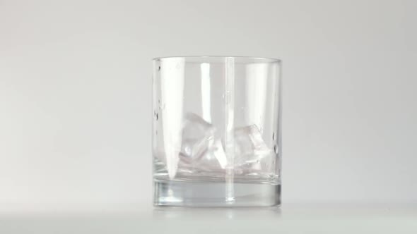 Ice Cubes Falling Into Glass and Splashing Water