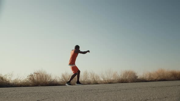 Focused Black Man Boxing Exercising Outdoors By the Road Side View