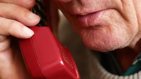 Portrait of an elderly Caucasian man talking on his home phone