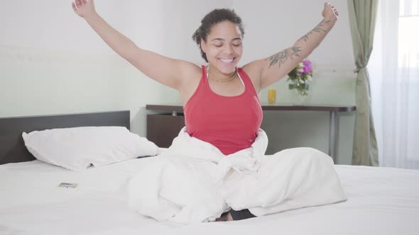 Attractive Smiling African American Woman Just Woke Up, She Stretching Her Body, Raising Her Arms
