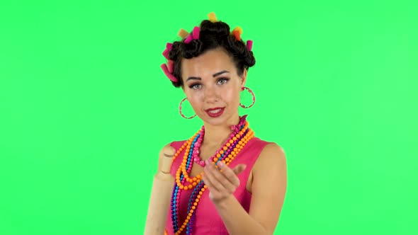 Girl with a Rolling Pin in Her Hands Seductively Looks at the Camera. Green Screen