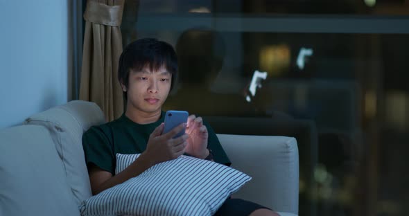 Man Use of Mobile Phone and Sit on Sofa at Night