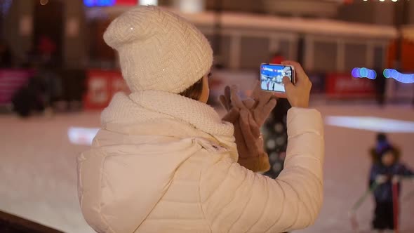 Happy Woman Taking Pictures of European Christmas Market Scene on Smartphone