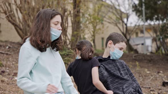 Coronavirus pandemic - kids wearing face masks to avoid contagion sitting bored